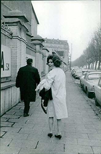 תצלום וינטג 'של אירינה דמיץ' הולך על המדרכה, במבט לאחור.