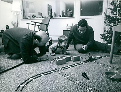 תצלום וינטג 'של שני גברים שמשחקים עם ילד וצעצועים שלו. פליטים יוונים